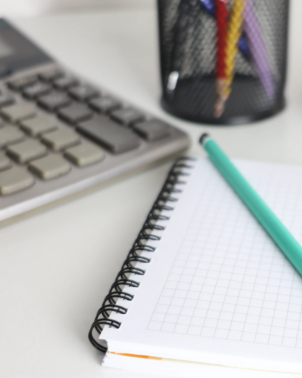 Desk with a calculator, notebook and pencil