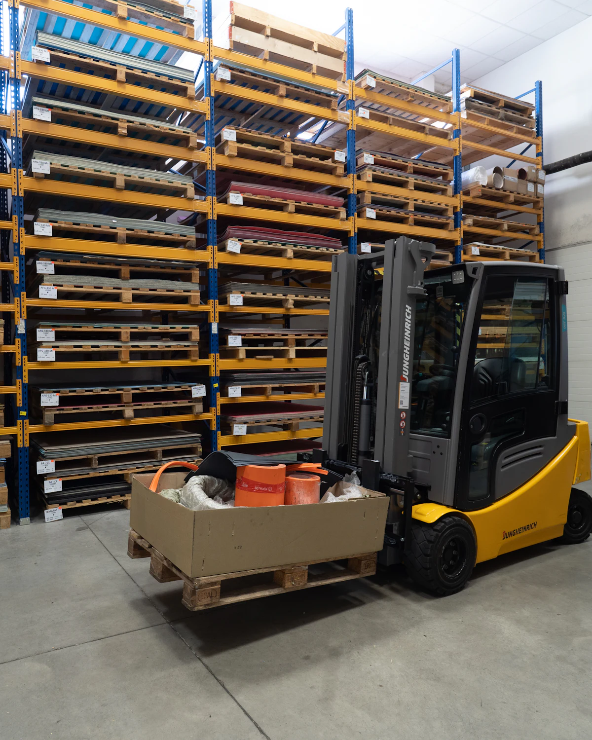 Forklift moving a boxed pallet in a warehouse